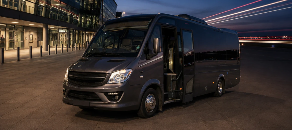 32-seater executive coach outside an airport terminal at dusk